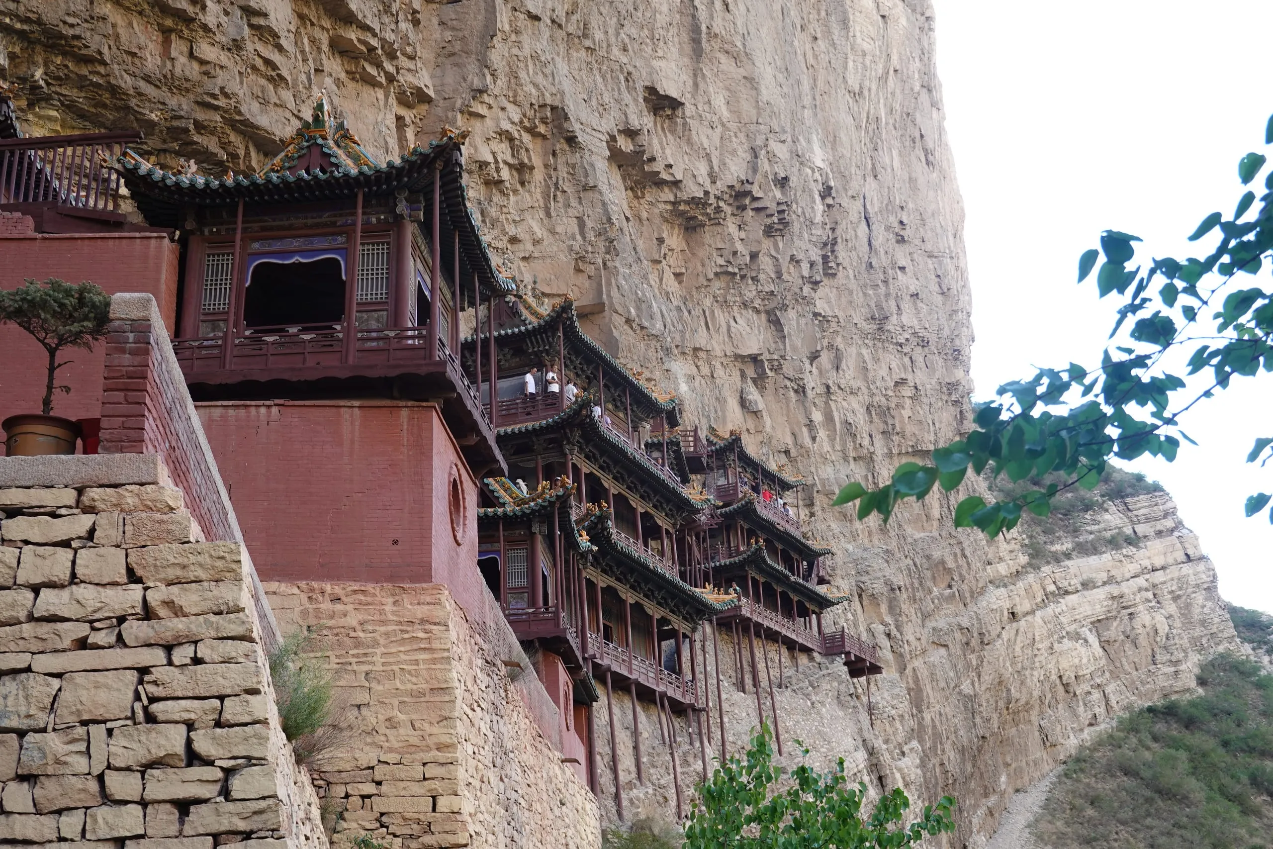 Hanging monastery on a cliff face at dusk, China
